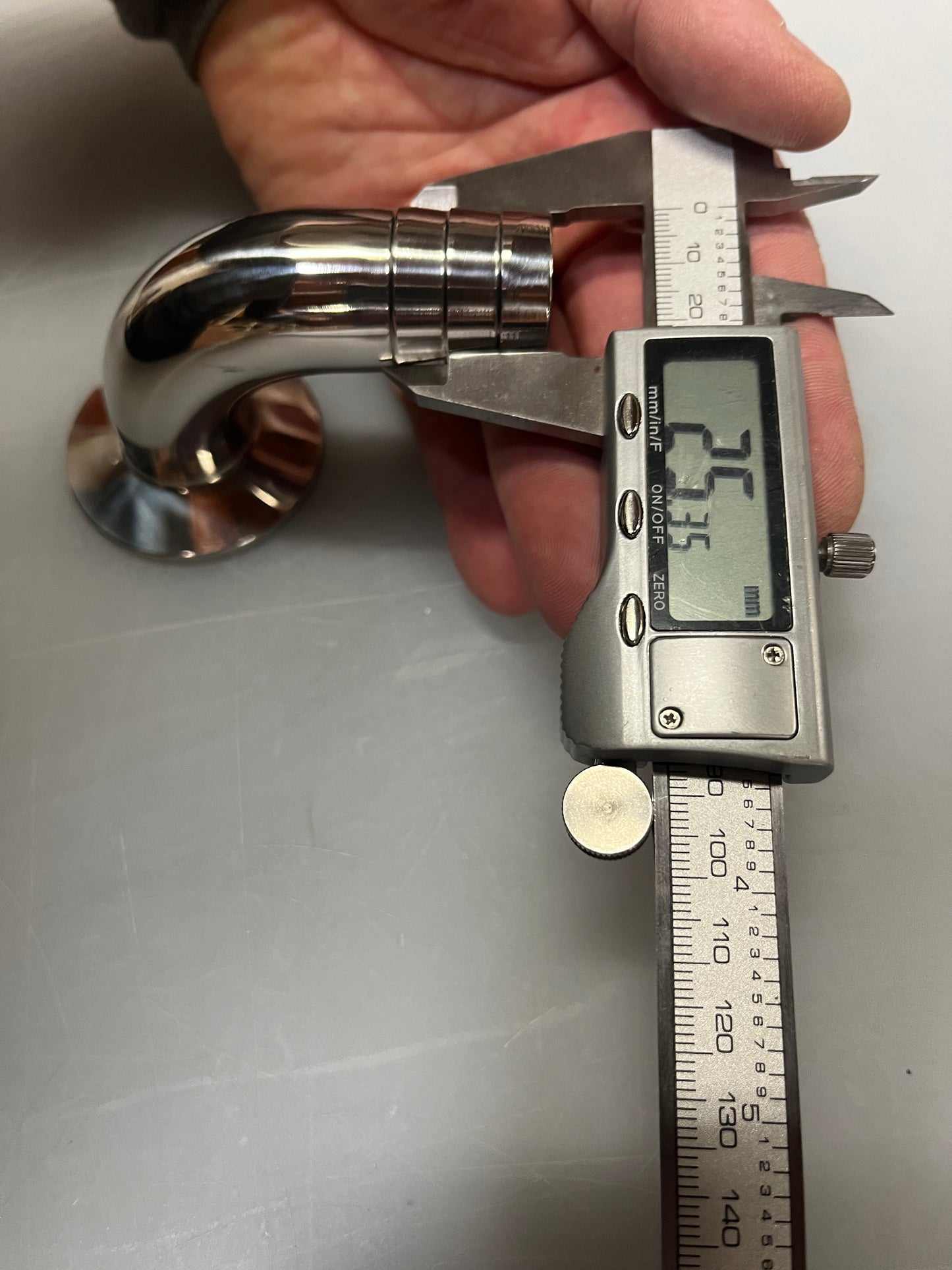 A collection of stainless steel sanitary hose barb fittings including various shapes and sizes, laid out on a flat surface.