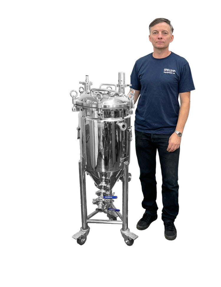 A person standing next to a stainless steel, jacketed, unitank conical fermenter with completely removable lids, heater ports, and polyurethane insulation.