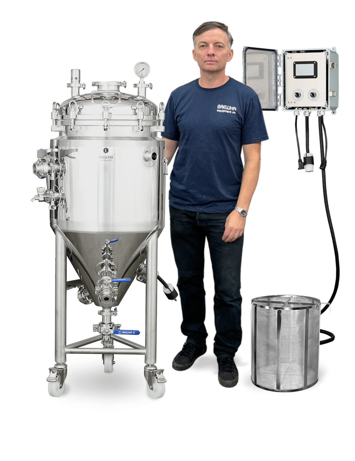 A man in a navy blue t-shirt and dark jeans stands next to a large stainless steel liquid holding  cylindro vessel with a conical bottom, alongside an electrical control panel and a cylindrical metal filter basket, all on a white background.